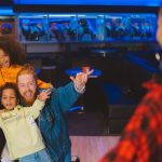 A happy family having fun and posing together at a bowling alley.